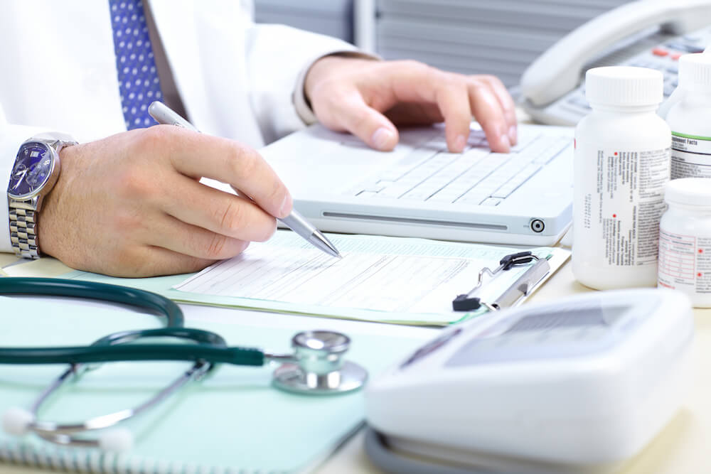 doctor writing at his desk